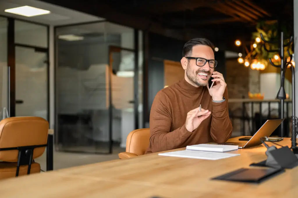 Business owner talking on the phone at his desk in a modern office